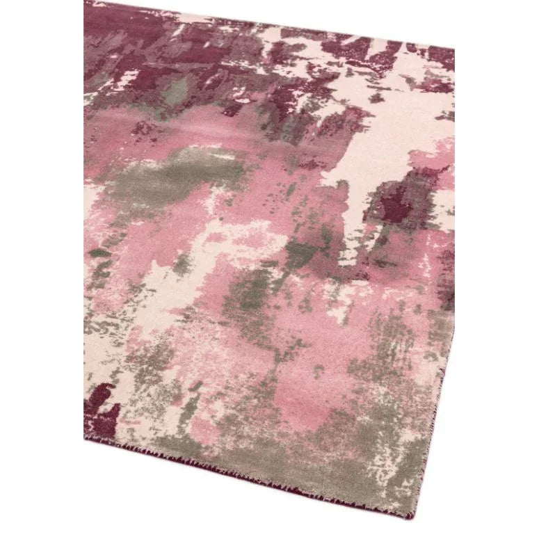 Abstract area rug with pink, cream, and taupe pattern, close-up of corner detail