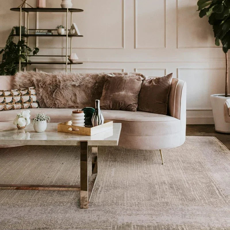 Velvet sofa with textured cushions beside modern marble coffee table in stylish living room