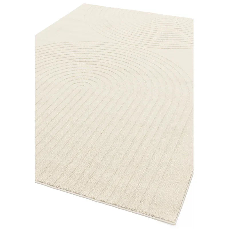 Beige area rug with subtle geometric linear texture, viewed from an angled perspective