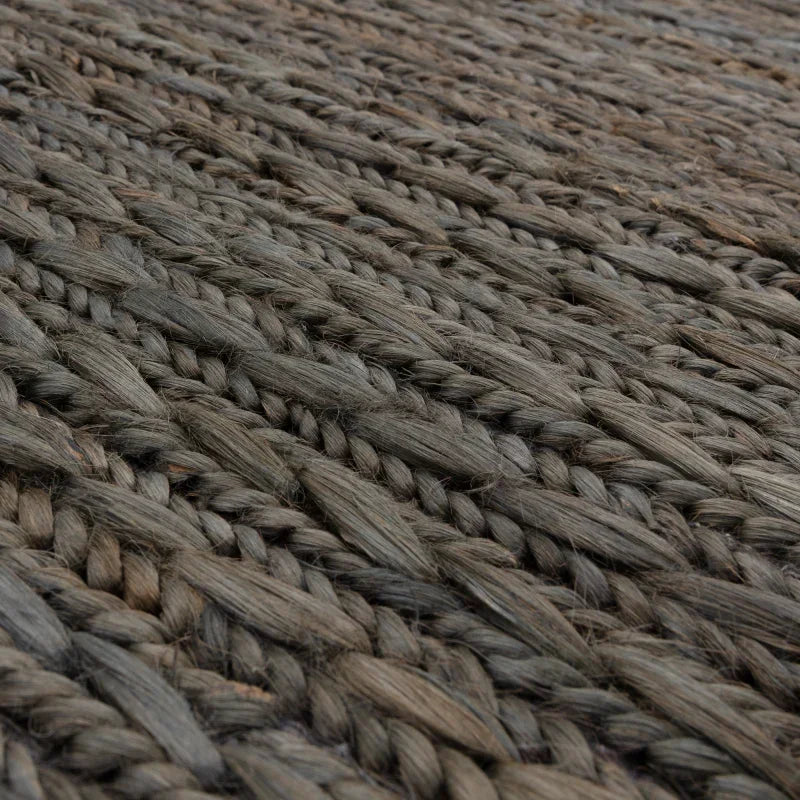 Close view of braided jute rug texture in natural grey color