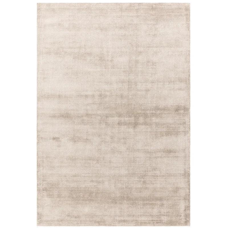 Rectangular beige area rug with soft, subtle pattern and short pile