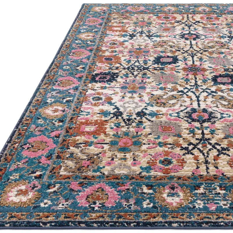 Traditional patterned area rug with blue, pink, and beige floral border and central design