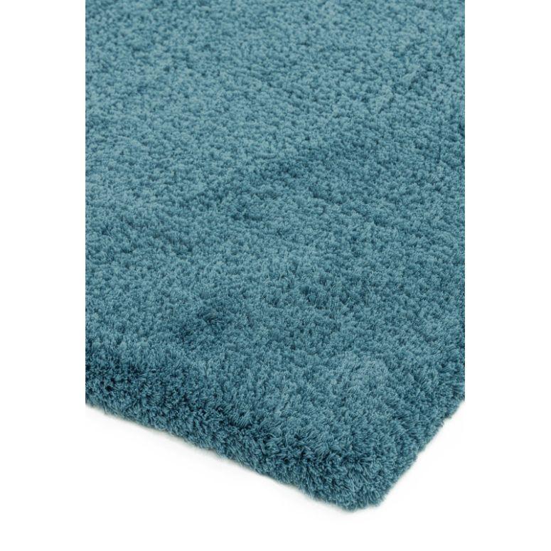 Close up of teal shaggy rug corner showing plush pile texture