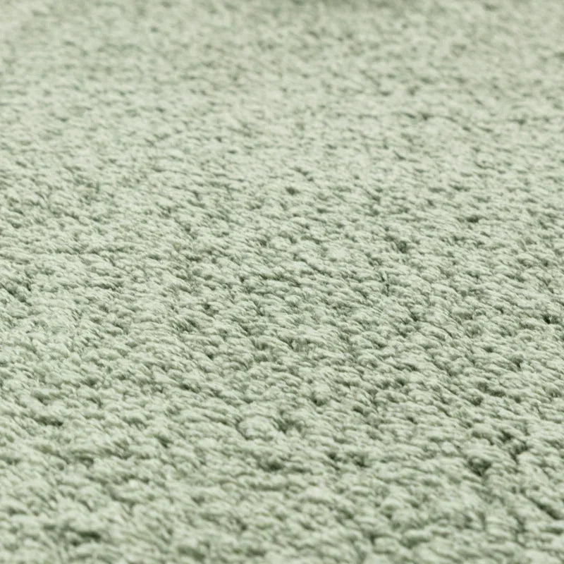 Close-up of soft sage green textured fabric upholstery on home furniture