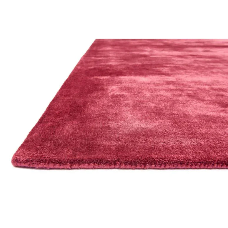 Plush red area rug with soft pile, close-up of corner and texture