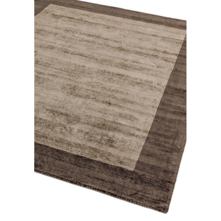 Rectangular beige and brown area rug with textured surface and wide contrasting border