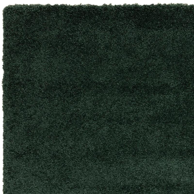 Dark green shaggy rug close-up showing thick textured pile