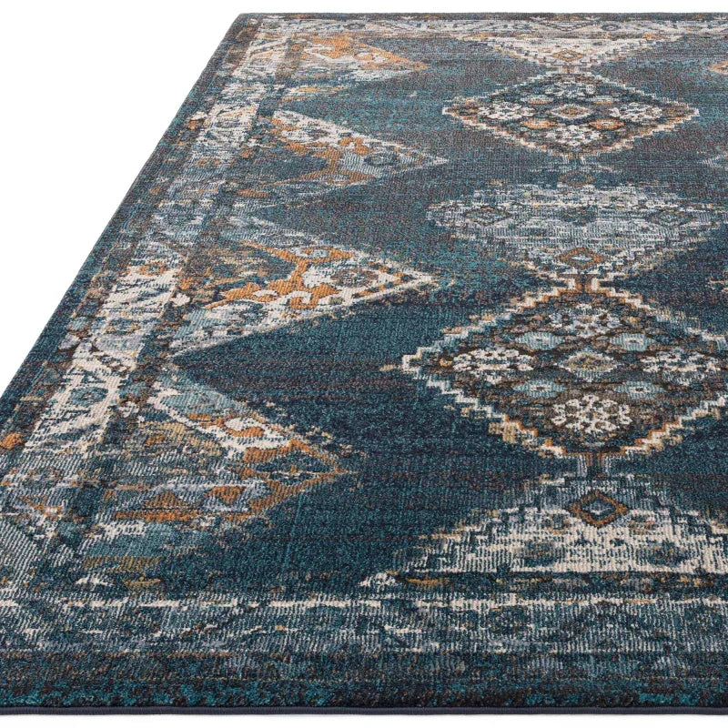 Blue patterned rug with geometric diamond motifs and distressed detailing