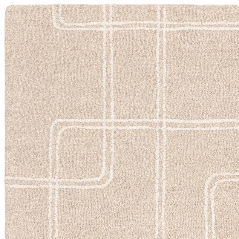Beige modern rug with white geometric line pattern and textured surface, close-up corner view