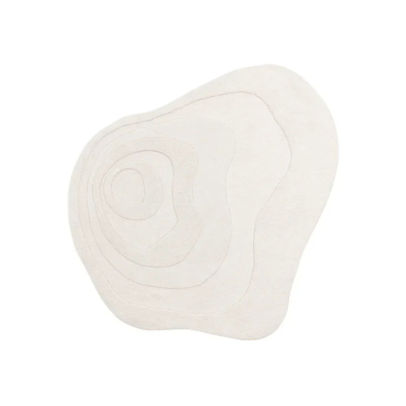Cream abstract rug with irregular shape and concentric curved line patterns