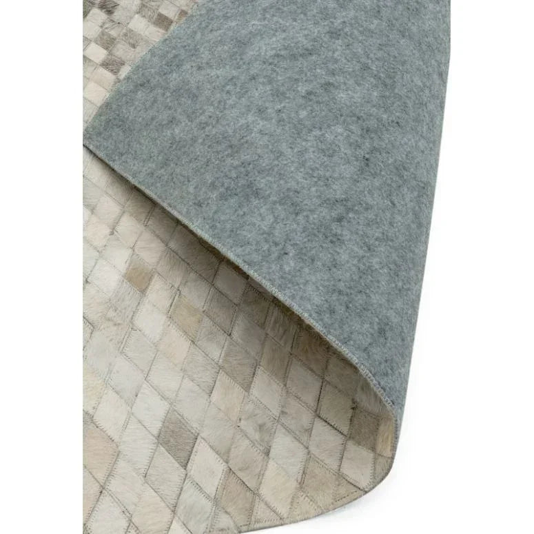 Beige patchwork rug with diamond pattern and grey felt backing corner detail