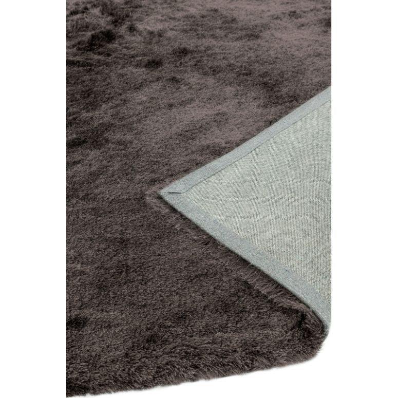 Dark grey shaggy rug with soft pile and visible fabric backing corner