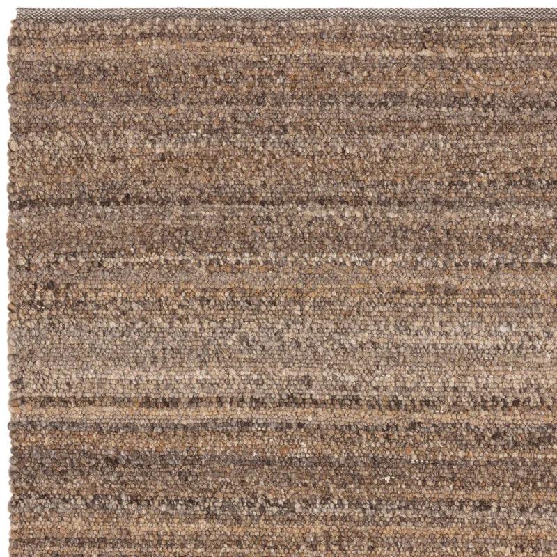 Closeup of brown textured wool rug with subtle striped pattern