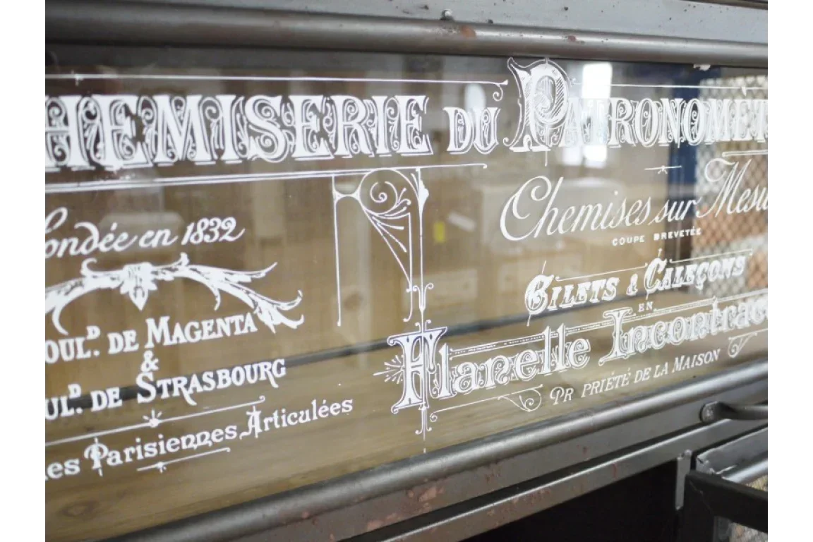 Vintage mirrored furniture panel with French lettering and ornate glass detailing