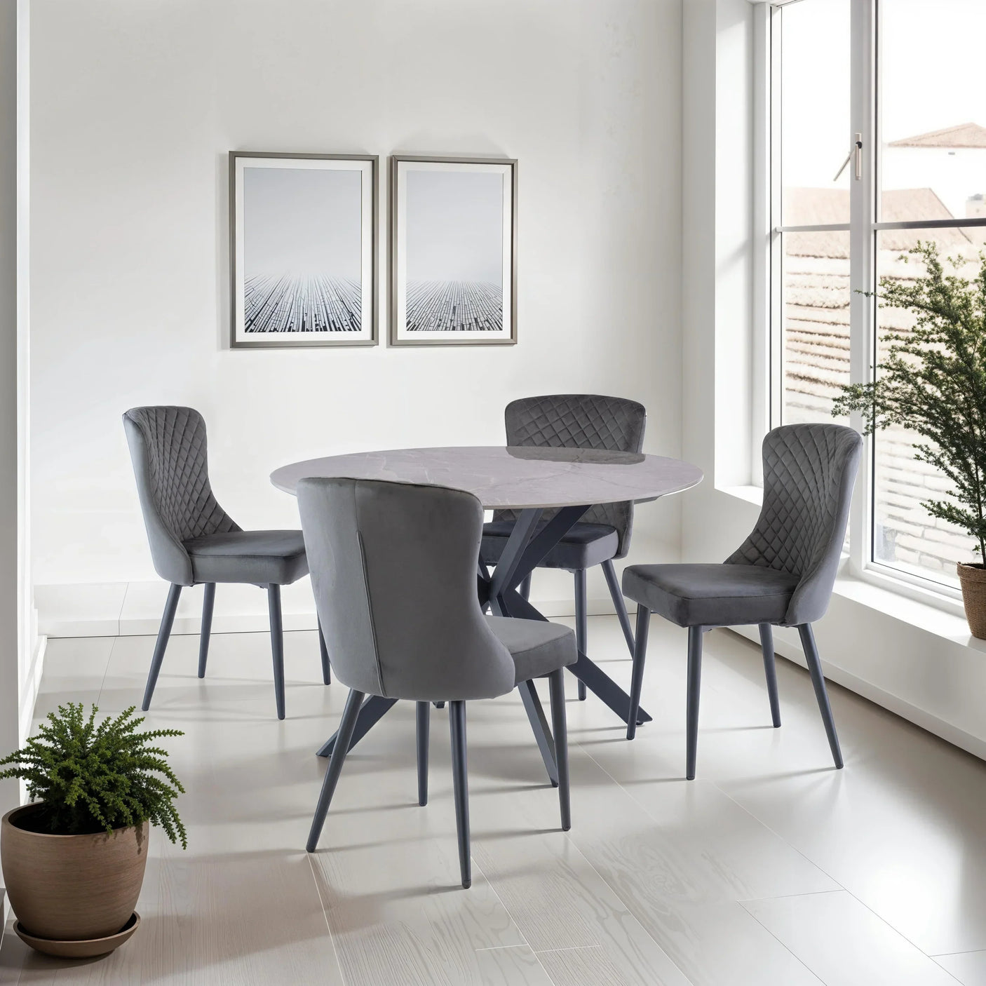 Grey velvet dining chairs with quilted backs and round marble dining table in modern room