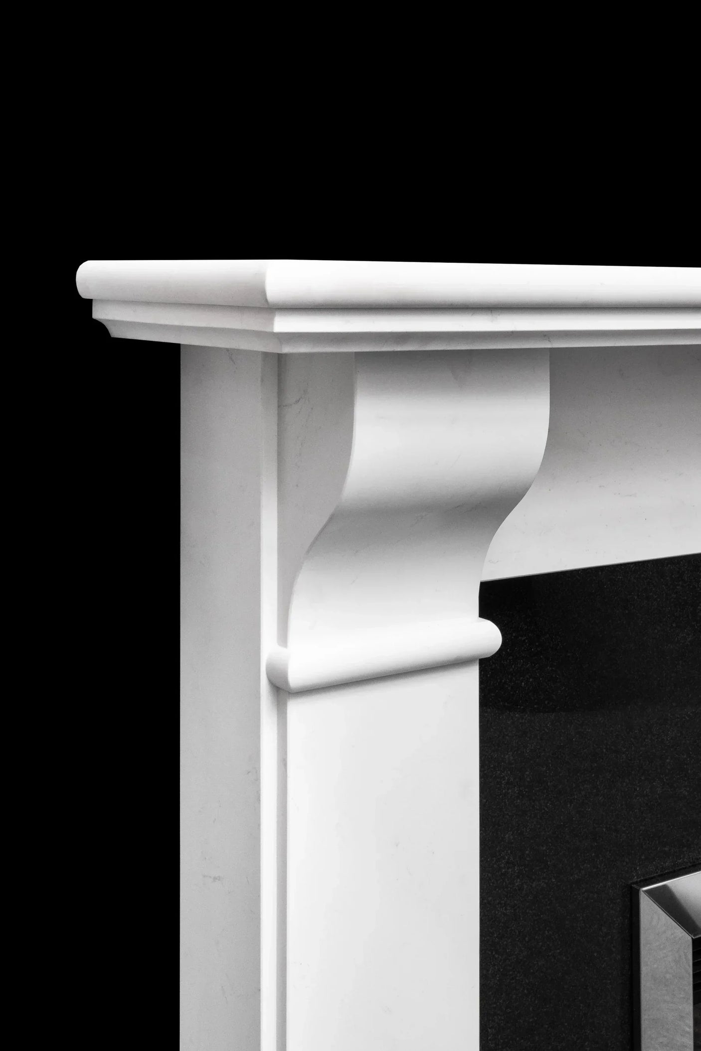 White marble fireplace surround with curved edge, close-up side view
