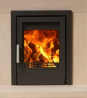 Black inset wood burning stove with glass door showing flame, set in light fireplace surround