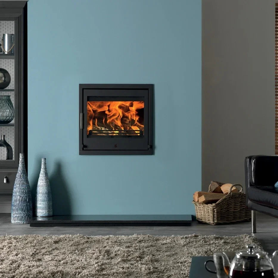 Black inset wood burning stove with fire in modern living room on blue feature wall