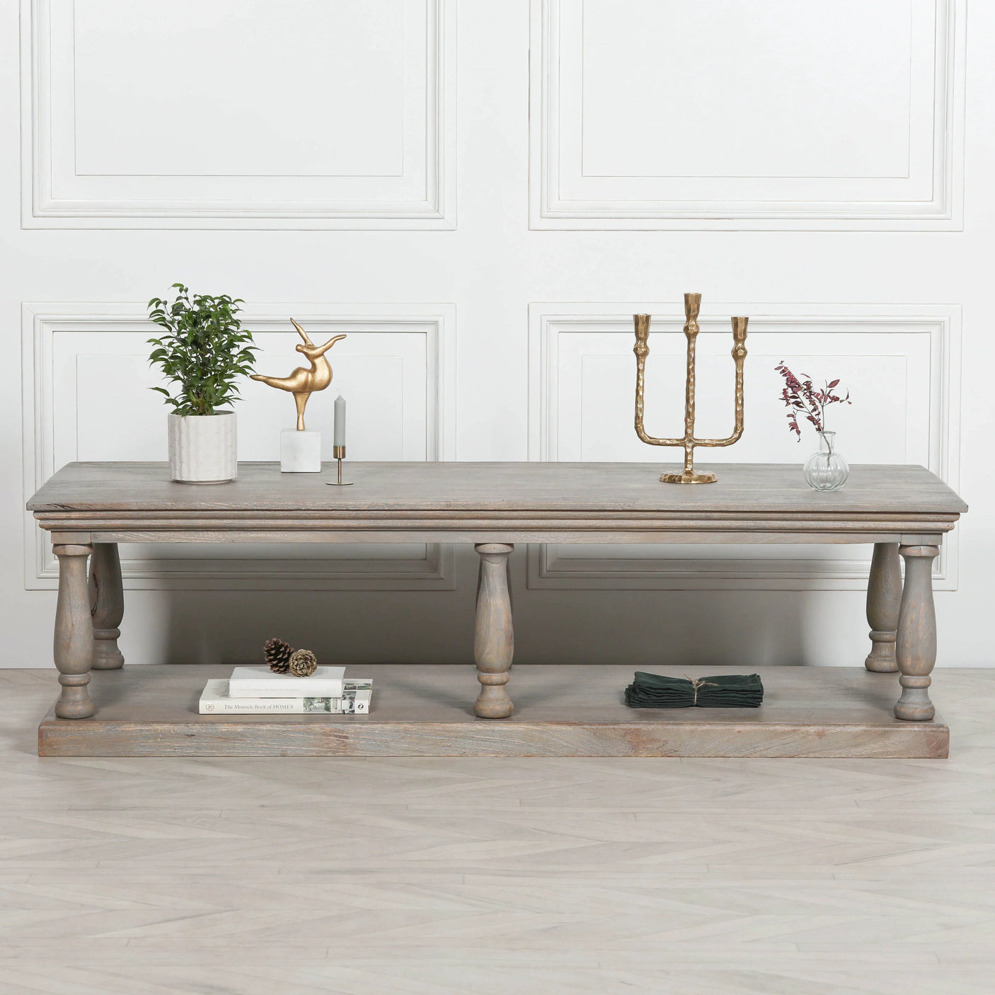 Rustic wood coffee table with turned legs, decorative accents, and lower shelf for storage