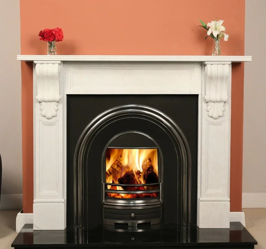 White marble fireplace with black cast iron insert and real fire, floral vases on mantel