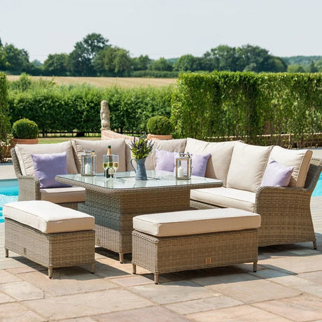 Rattan garden furniture set with cream cushions and glass top table by poolside