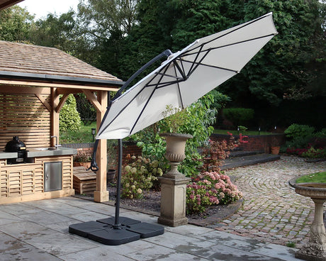 Garden cantilever parasol with cream canopy and black pole on patio near outdoor kitchen