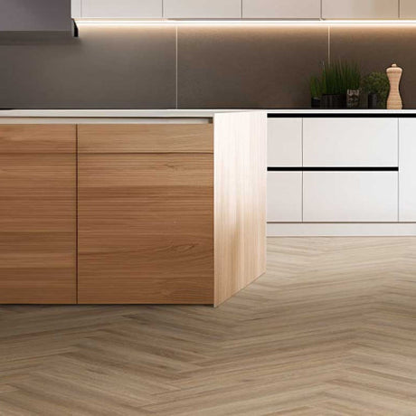 Light oak effect kitchen cabinets paired with modern white units and chevron flooring