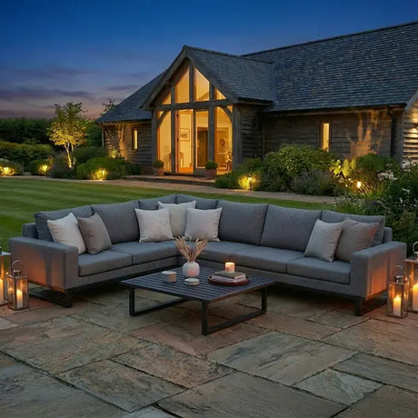 Large grey corner sofa set with cushions on a stone patio, modern outdoor furniture setup