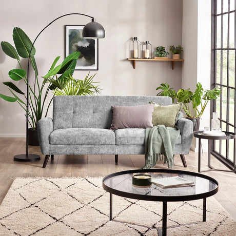 Dove grey three seater fabric sofa with cushions in a modern living room, next to large window