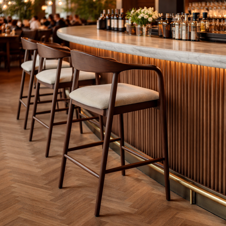 Maya barstools with wooden frame and fabric seat at a modern marble-topped bar counter
