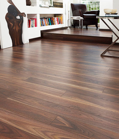 Dark wood flooring in living room with bookshelf, armchair, and modern decor