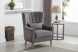 Graphite upholstered armchair with wooden legs beside a round side table in modern living room