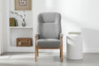 Grey upholstered armchair with wooden frame in modern living room setting