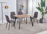 Walnut dining table with black metal legs and four grey upholstered chairs in modern room