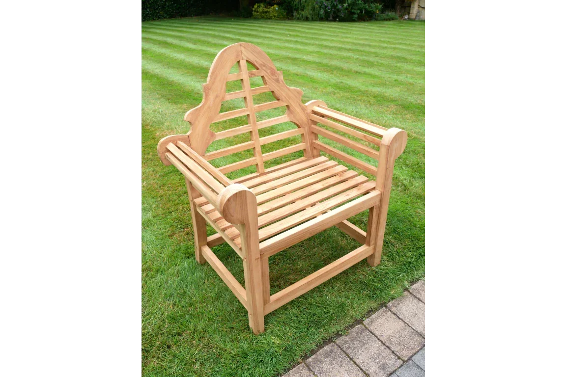 Teak wooden garden bench with curved backrest on lawn