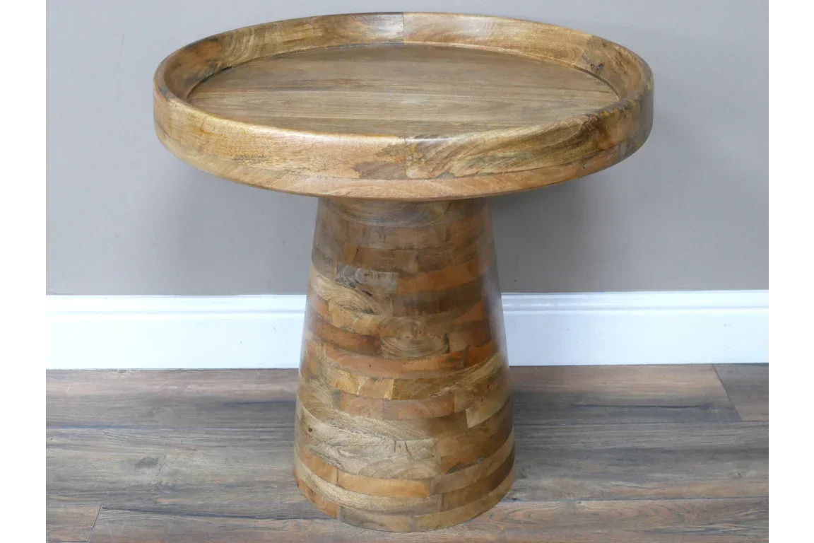 Round wooden side table with thick edge and tapered base on laminate floor