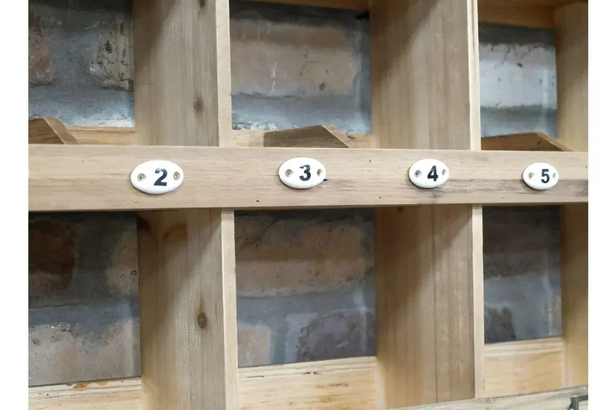 Wooden multi-compartment storage unit with numbered sections against a brick wall