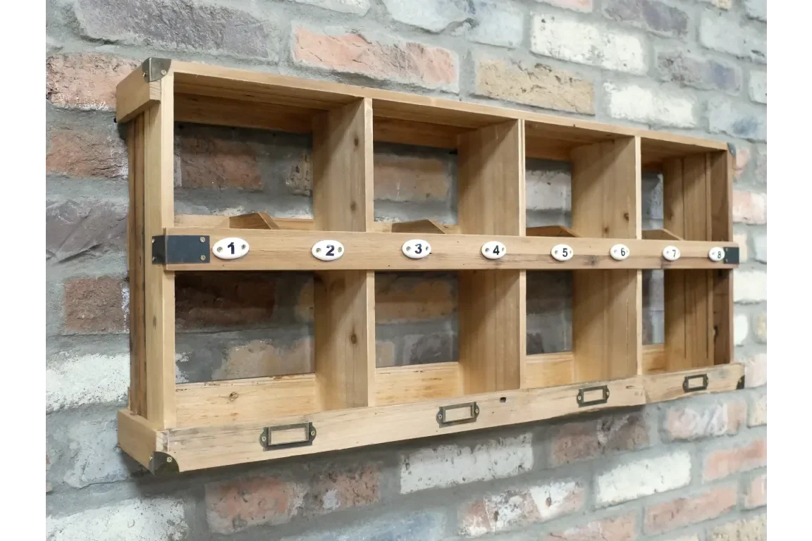 Wooden wall mounted storage organiser with eight numbered cubby holes against brick wall