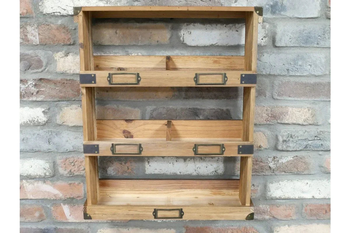 Three tier wooden wall shelf with metal label holders against brick wall