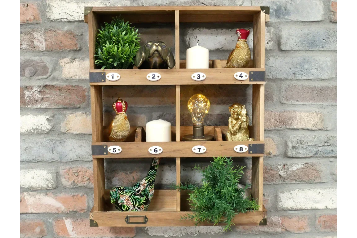 Wooden wall shelf with eight compartments holding ornaments, candles, plants, and a light bulb
