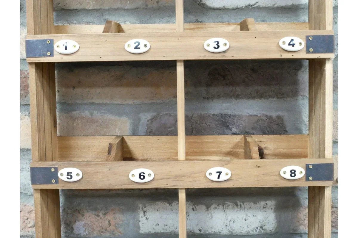 Wooden pigeon hole shelving unit with eight numbered compartments against brick wall