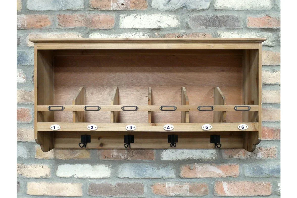 Wooden wall mounted mail sorter with six compartments and metal hooks on brick background