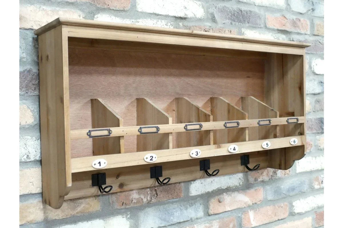 Wooden wall mounted organiser with six storage slots and hooks against brick wall