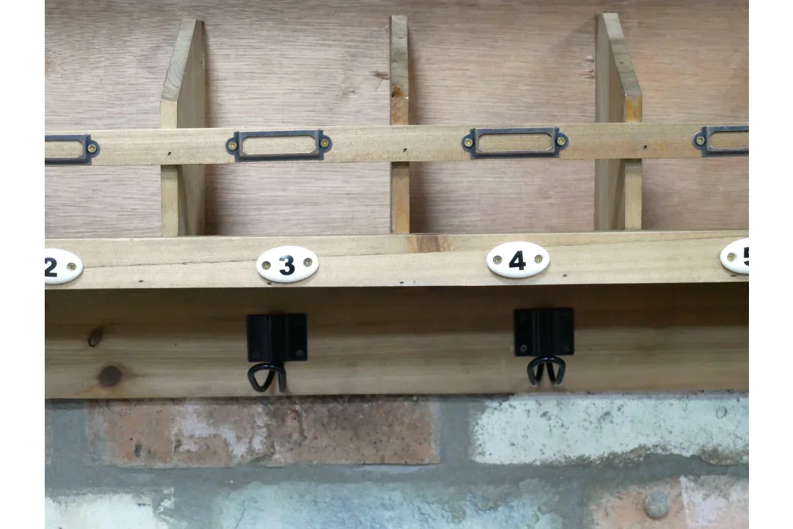 Wooden hallway organiser with numbered cubbies and metal hooks mounted on wall