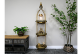 Tall 3 tier metal shelves with decorative items, displayed in a room with grey carpet and potted plants.