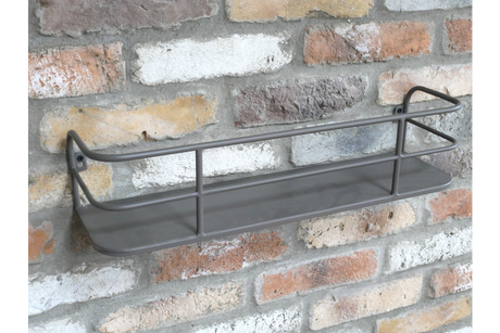 Wall-mounted grey metal shelf with raised bars, angled view against a textured brick wall background.
