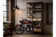 Motorbike-shaped bar cabinet in black metal and wood with shelves, drawers, and glass racks in a vintage living room setting.