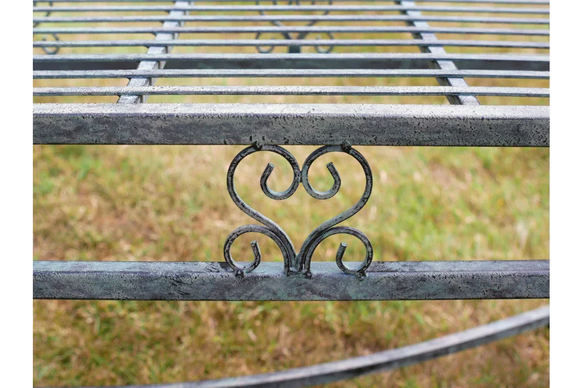 closeup of metal garden bench with decorative scrollwork and horizontal slats