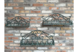 Set of 3 green metal wall shelves with ornate scrollwork detail, mounted on a rustic brick wall, viewed from the front.