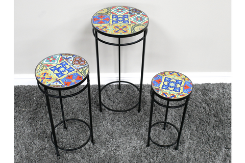 Set of 3 round side tables with black metal legs and colorful patterned ceramic tile tops on gray carpet.